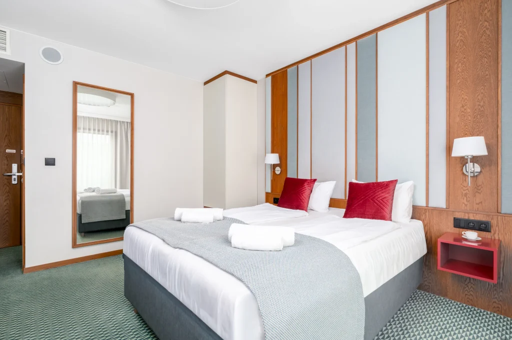 Double bed and a mirror by the room entrance