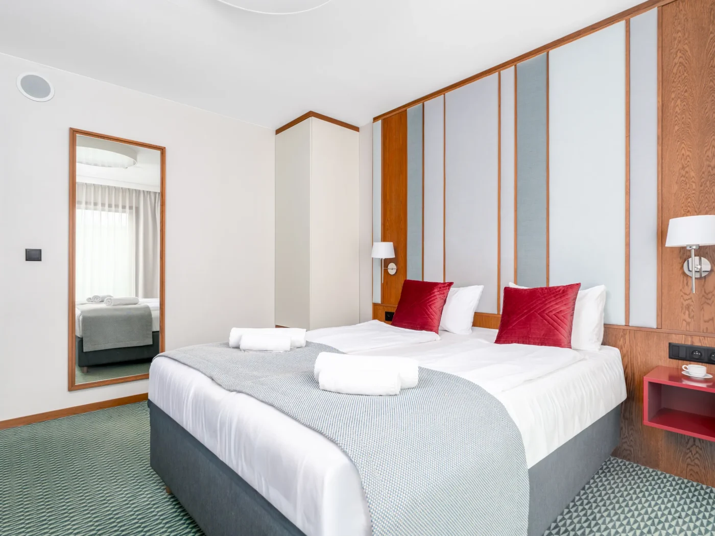 Double bed and a mirror by the room entrance