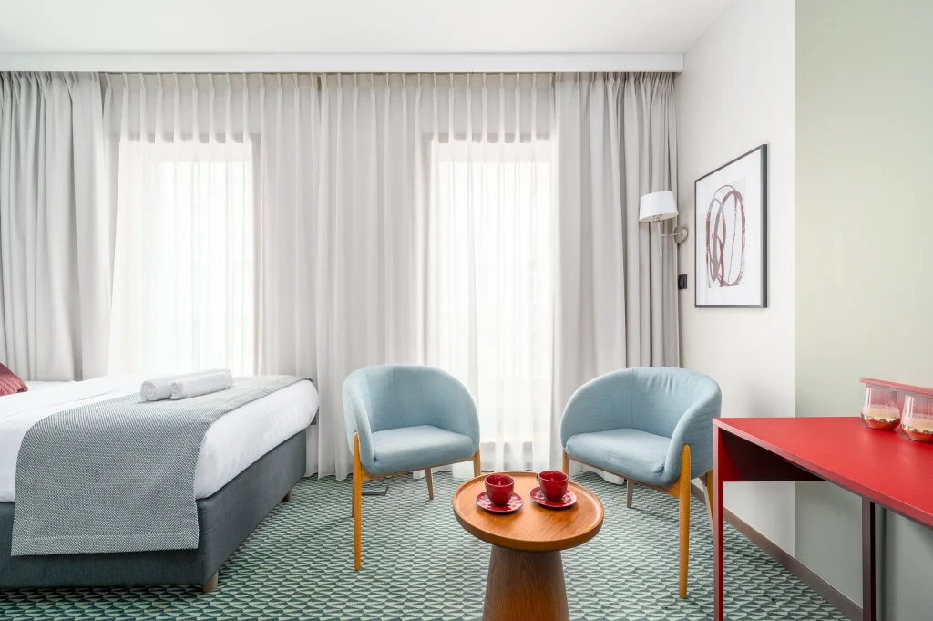 Two beds and a seating area by the window