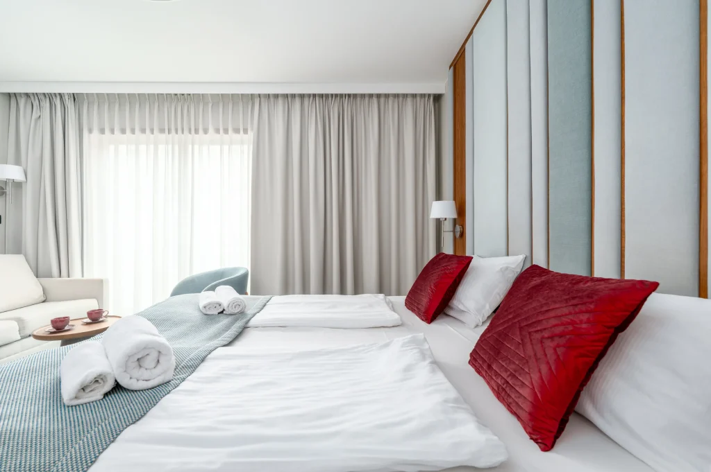 Towels and red cushions on the bed