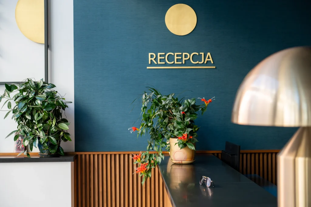 Entrance area with a Recepcja sign and brass lamp